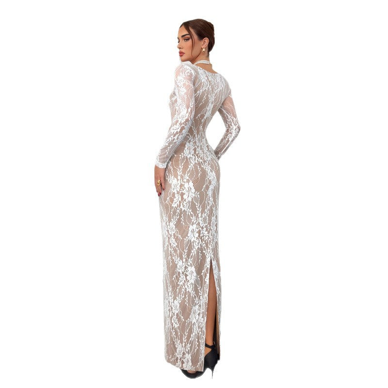 Model in a long white lace dress with delicate floral patterns, standing against a plain white background in a studio.