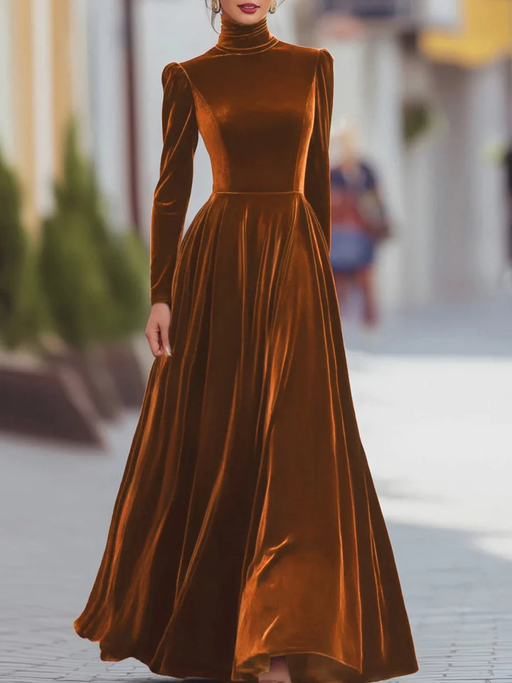 Elegant brown velvet dress with long sleeves and a flowing skirt, showcased in an urban environment.