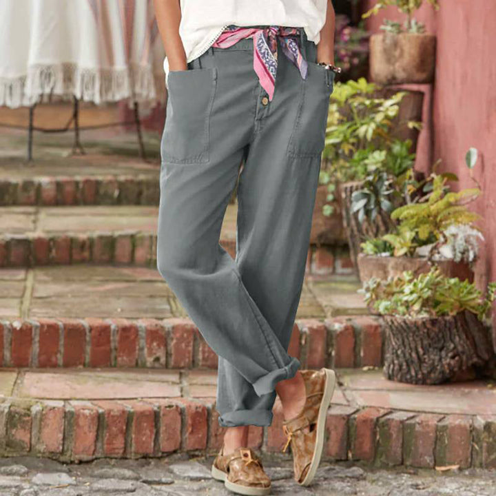 Gray casual pants with button front and scarf belt, styled in an outdoor garden area.