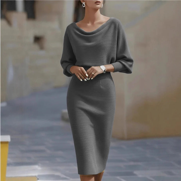 Sophisticated gray midi dress with draped neckline and three-quarter sleeves, depicted in an outdoor scene.