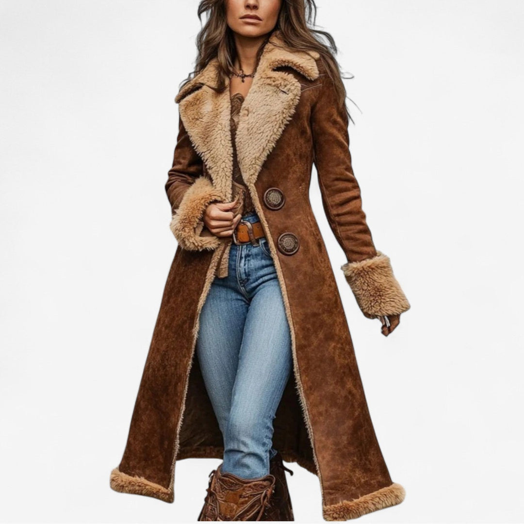 Woman wearing a long, brown fur coat with soft, plush trim, paired with blue jeans and a belt, set against a white background.