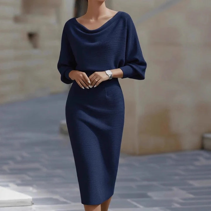 Stylish navy blue midi dress with draped neckline and three-quarter sleeves, set in an outdoor background.