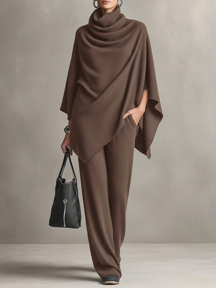 Brown two-piece set with elegant draped top and wide-leg pants in studio setting, accessorized with black handbag.