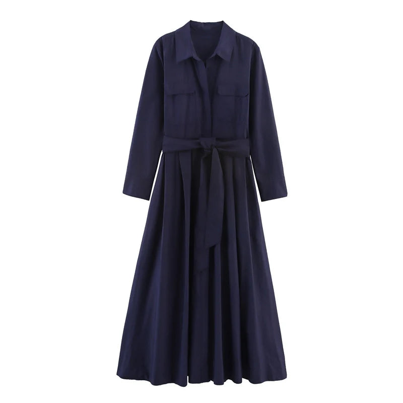 Studio image of an elegant navy loose dress with long sleeves and a belted waist on a white background.