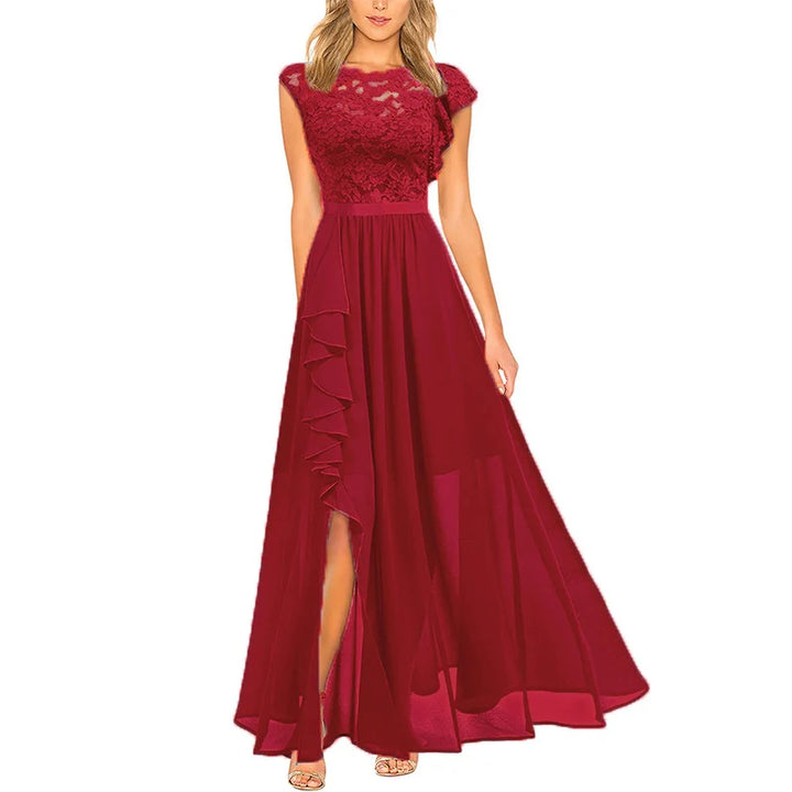 Elegant red dress with lace bodice and flowing skirt, featuring a ruffled slit, displayed on a model in studio setting.