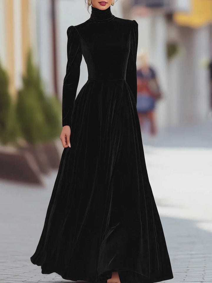 Elegant black velvet dress featuring long sleeves and a flowing skirt, worn in a stylish city scene.