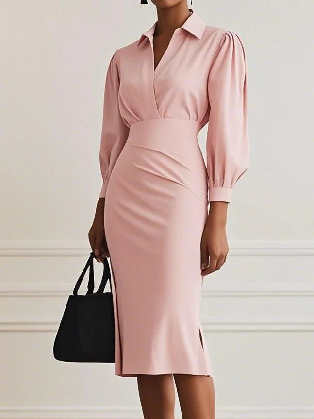 Soft pink elegant maxi dress with puff sleeves and cinched waist, holding a black tote bag in a studio backdrop.