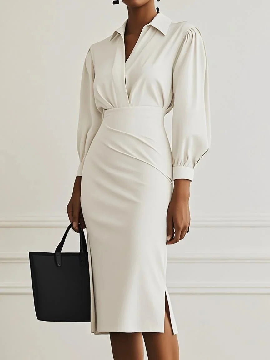 Ivory elegant maxi dress highlighted by puff sleeves and structured fit, accompanied by a black tote in studio environment.