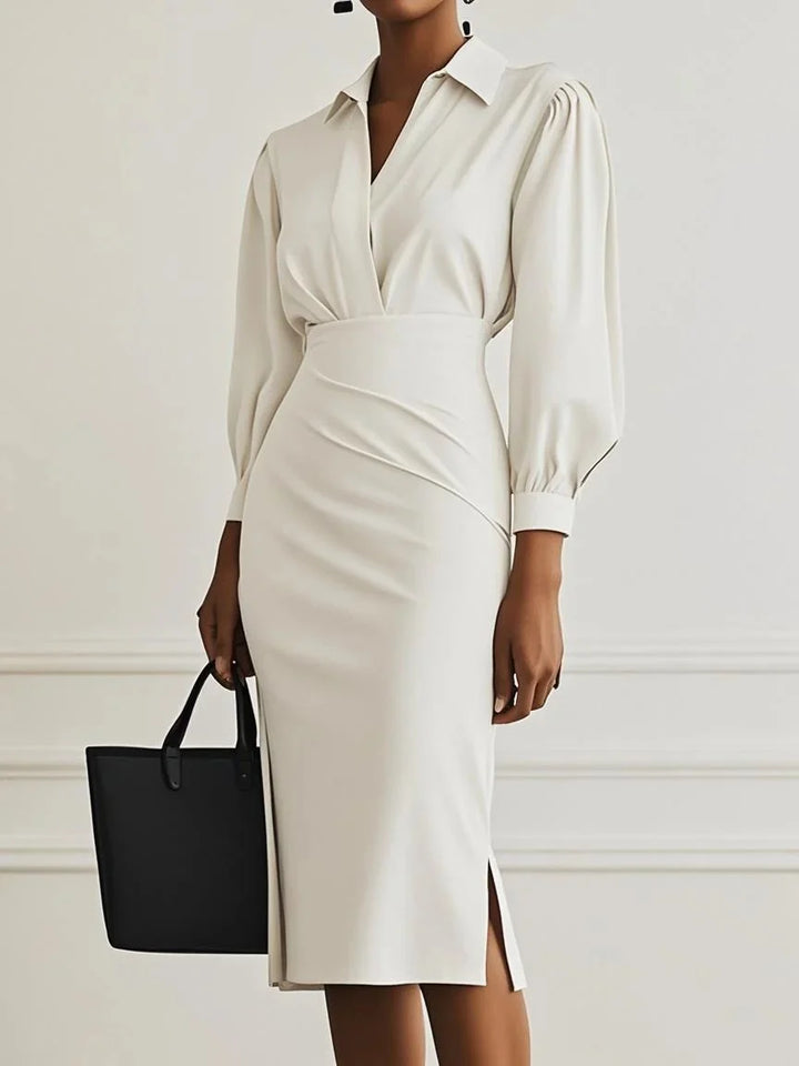 Ivory elegant maxi dress highlighted by puff sleeves and structured fit, accompanied by a black tote in studio environment.