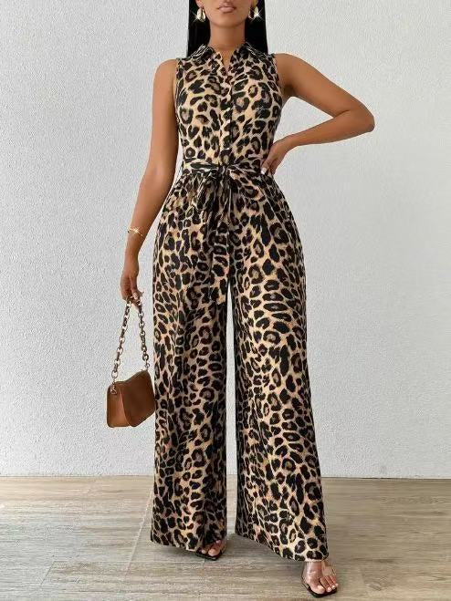 Leopard print jumpsuit with sleeveless design and waist tie, worn by person with brown handbag. Set against white wall.