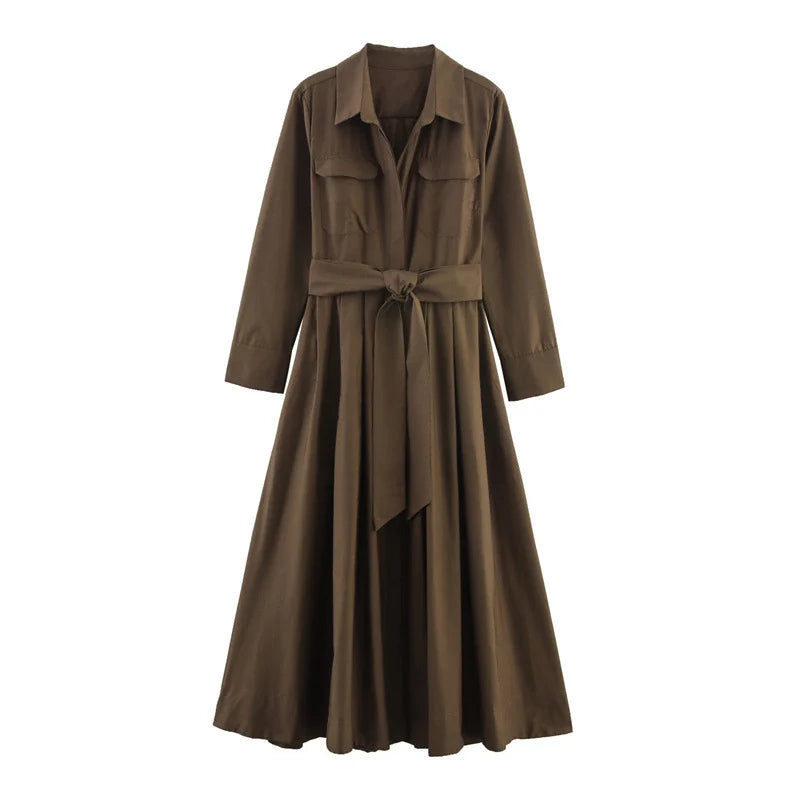 Studio image of an elegant brown loose dress with long sleeves and a belted waist on a white background.