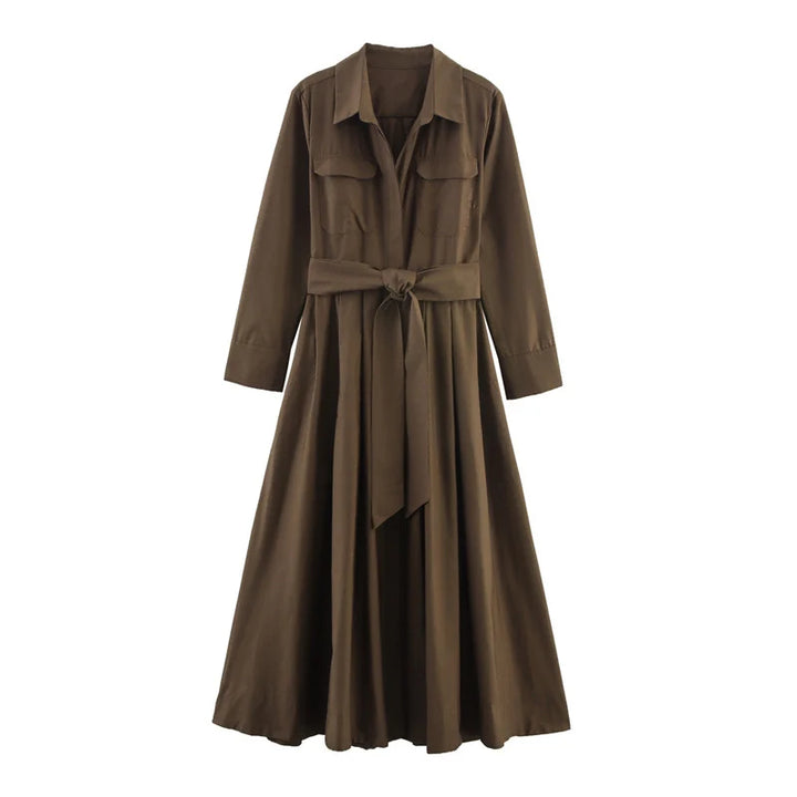 Studio image of an elegant brown loose dress with long sleeves and a belted waist on a white background.