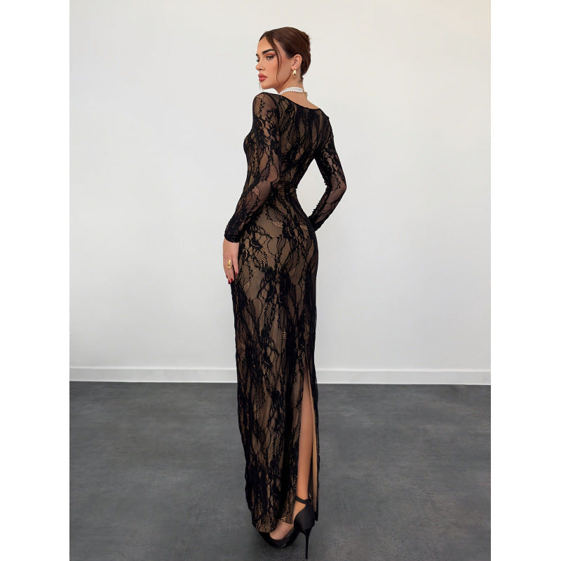 Model wearing a long, black lace dress with intricate patterns, standing in a studio against a plain white background.