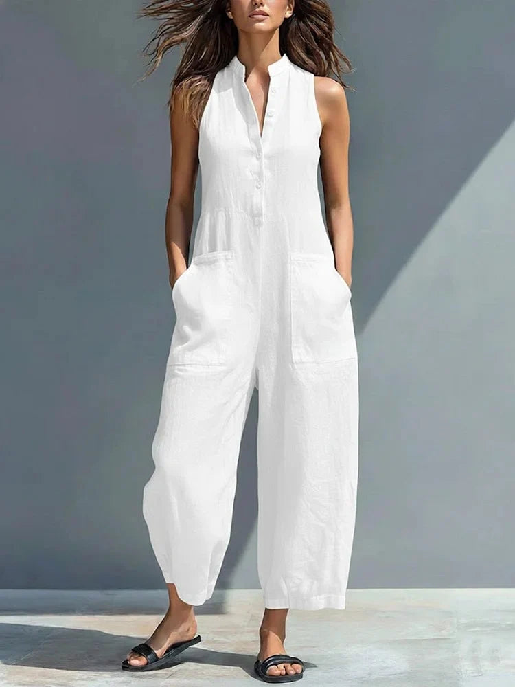 Woman wearing a white sleeveless jumpsuit with pockets, outdoors in natural light.