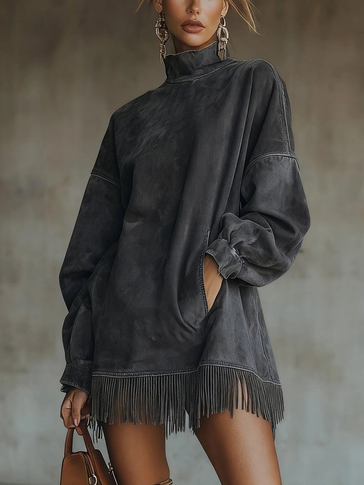 Gray suede fringe dress with high neck and long sleeves, modeled indoors against a blurred background, paired with a brown handbag.