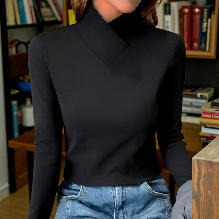 Black high-neck sweater with long sleeves, worn indoors. Background features bookshelves and a warm setting.