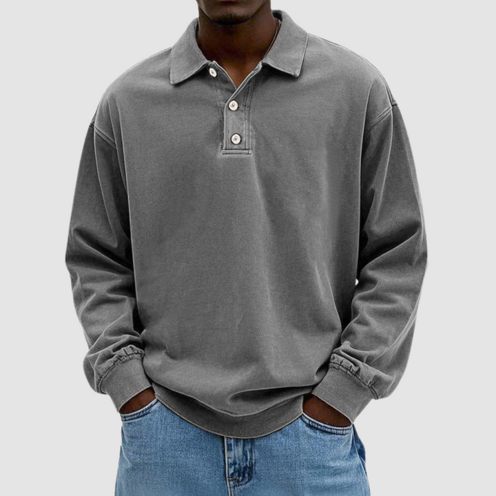 Gray vintage long sleeve polo shirt worn by model, hands in pockets, with light jeans against a plain background.
