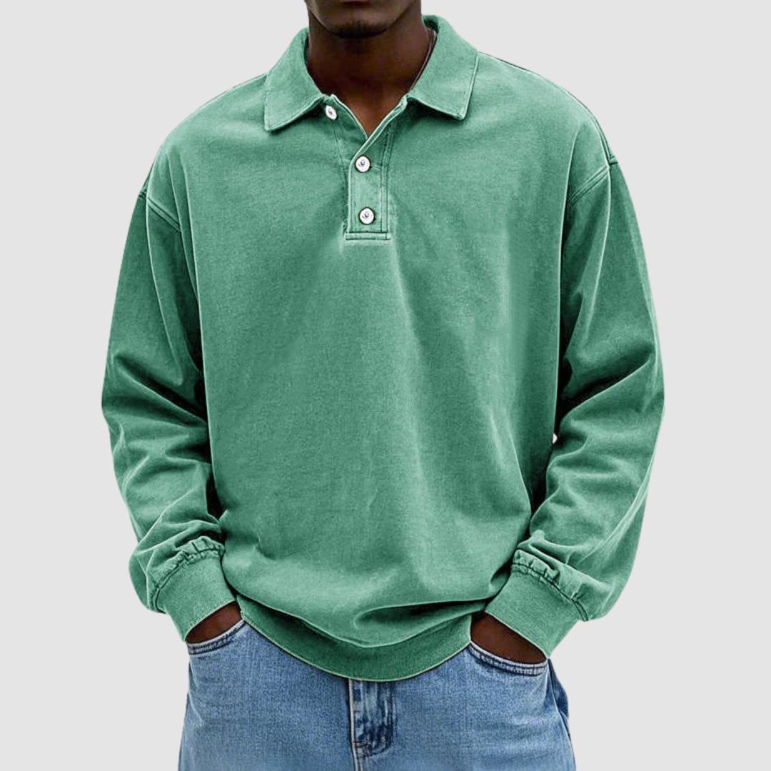 Green vintage long sleeve polo shirt worn by model, hands in pockets, with light jeans, studio setting.