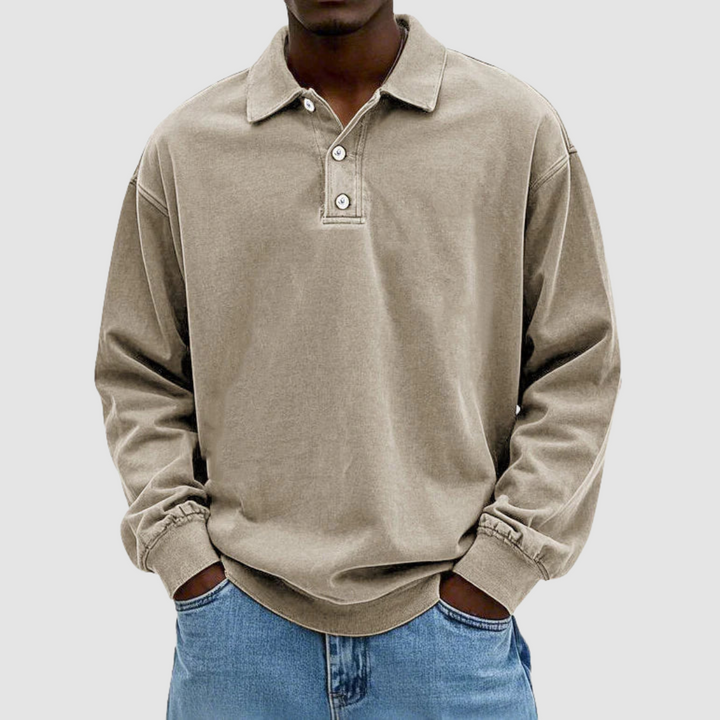 Beige vintage long sleeve polo shirt worn by model, hands in pockets, paired with light jeans, plain backdrop.