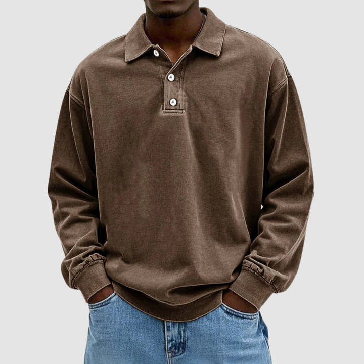 Brown vintage long sleeve polo shirt worn by model, hands in pockets, with light jeans, simple background.