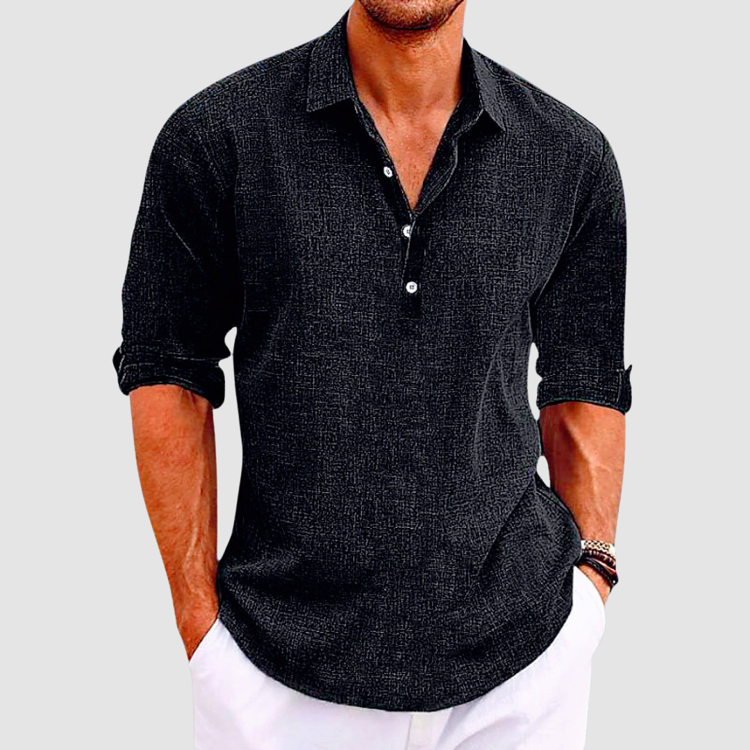 Black collared shirt with rolled up sleeves and buttons, worn by a person with hands in white pants pockets.