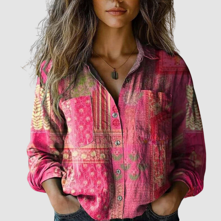 Pink blouse with a mix of floral and geometric patterns, buttoned, shown on a woman against a neutral setting.