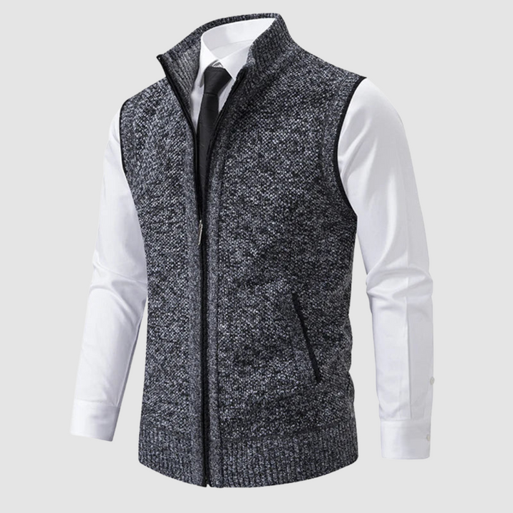 Dark gray fleece gilet displayed over white shirt and black tie in studio.