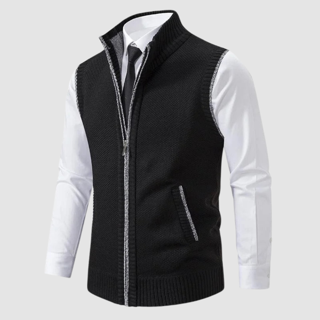 Black fleece gilet displayed over white shirt and black tie in studio.