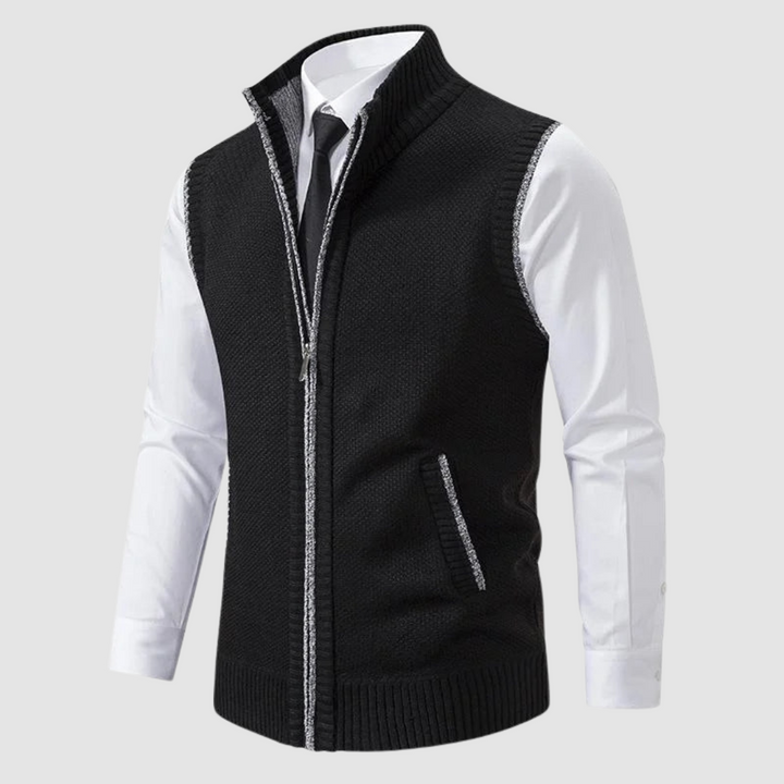 Black fleece gilet displayed over white shirt and black tie in studio.