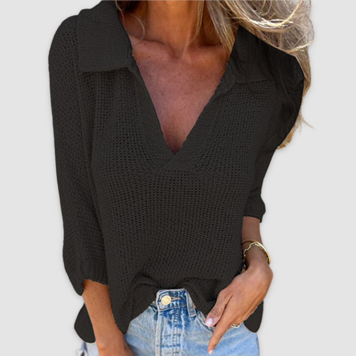 Black V-neck top with three-quarter sleeves and blue jeans, shown against a simple backdrop.