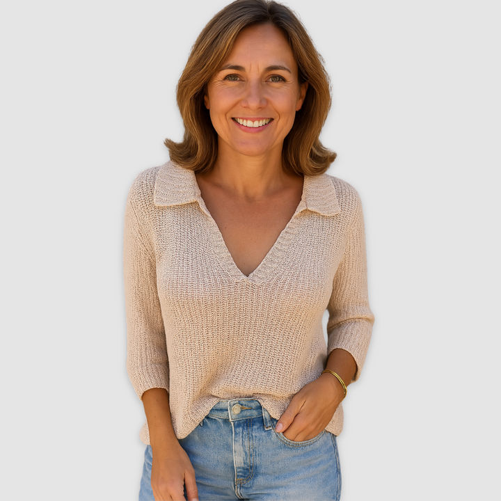 Elegant V-neck top in beige with three-quarter sleeves, worn by a person in blue jeans against a plain background.