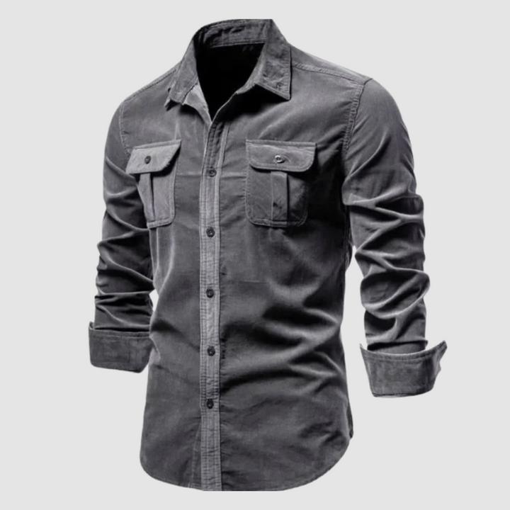 Dark gray corduroy shirt featuring buttoned flap pockets and rolled sleeves, set against a plain light background.