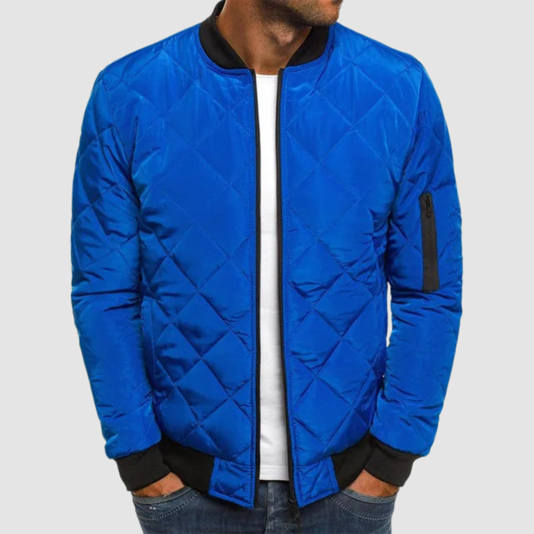 Blue quilted spring jacket with zipper and ribbed cuffs in studio setting.