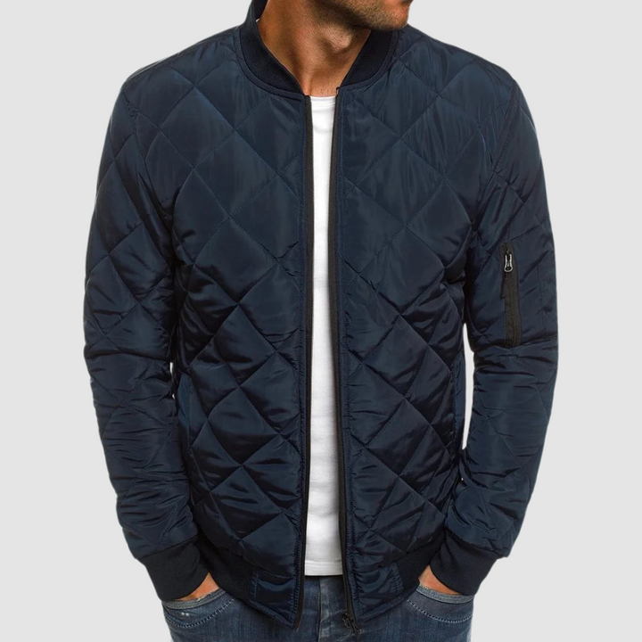 Navy quilted spring jacket with zipper and ribbed cuffs in studio setting.