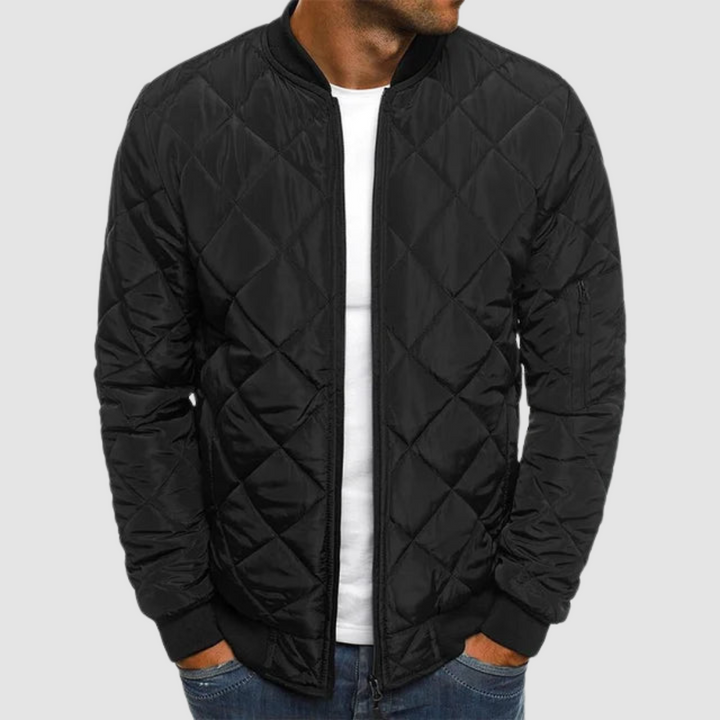 Black quilted spring jacket with zipper and ribbed cuffs in studio setting.