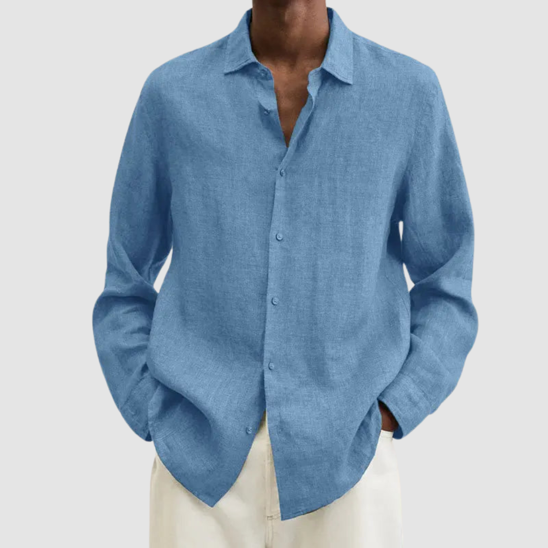 Model wearing a light blue lightweight shirt with hands in pockets, against a light gray background.