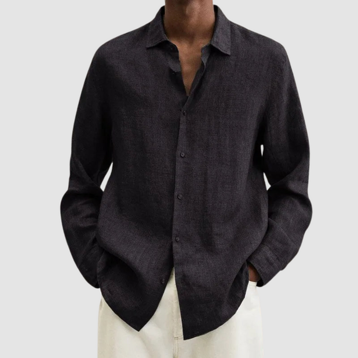 Model wearing a dark gray lightweight shirt with hands in pockets, against a light gray background.