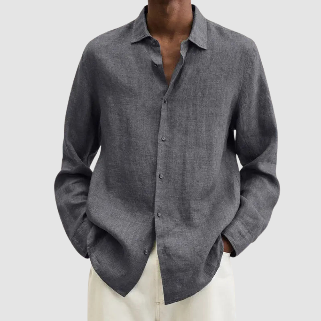 Model wearing a gray lightweight shirt with hands in pockets, against a light gray background.
