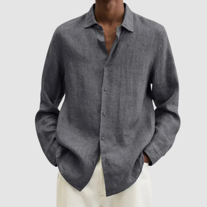 Model wearing a gray lightweight shirt with hands in pockets, against a light gray background.