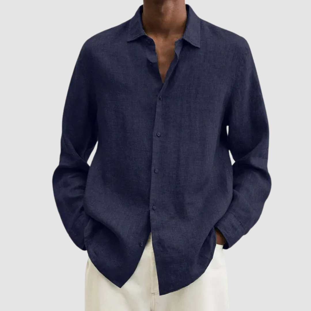 Model wearing a navy lightweight shirt with hands in pockets, against a light gray background.