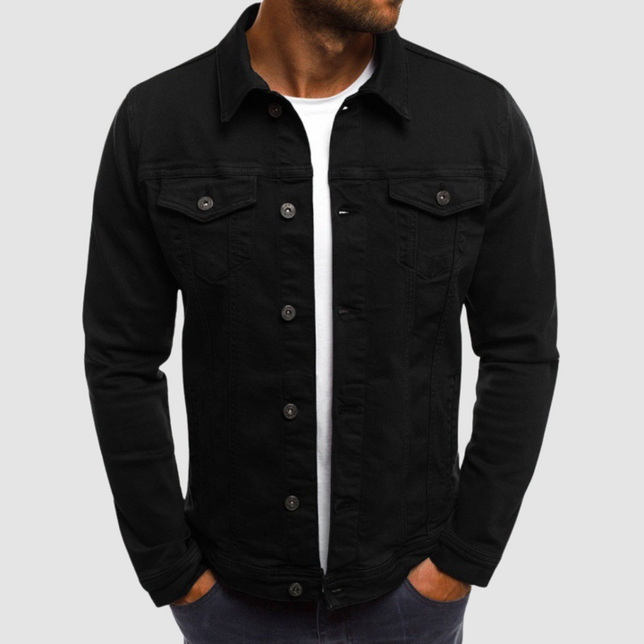 Model wearing a black jacket with button closure and chest pockets, paired with a white shirt, against a gray background.