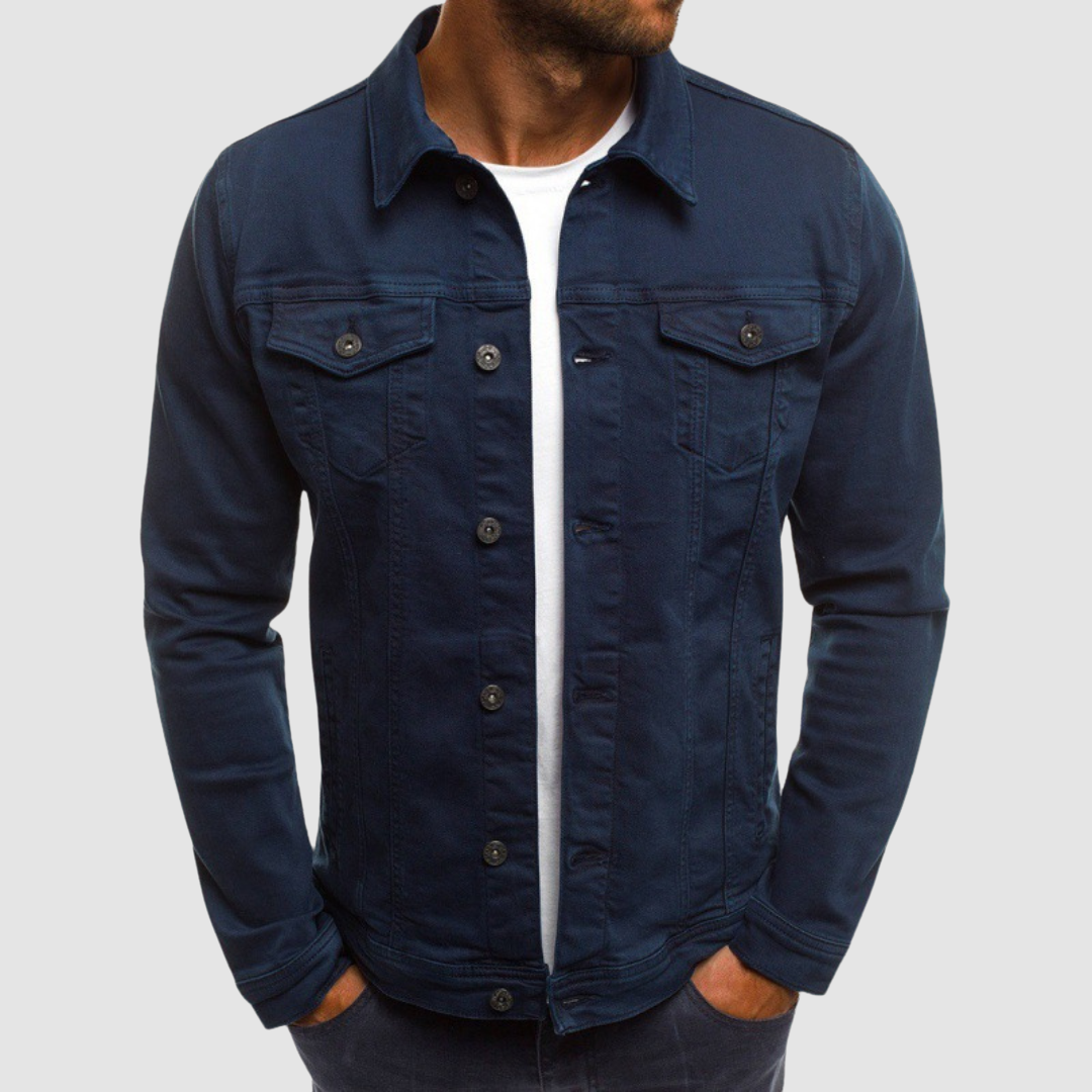 Model wearing a navy blue jacket with button closure and chest pockets, paired with a white shirt, against a gray background.