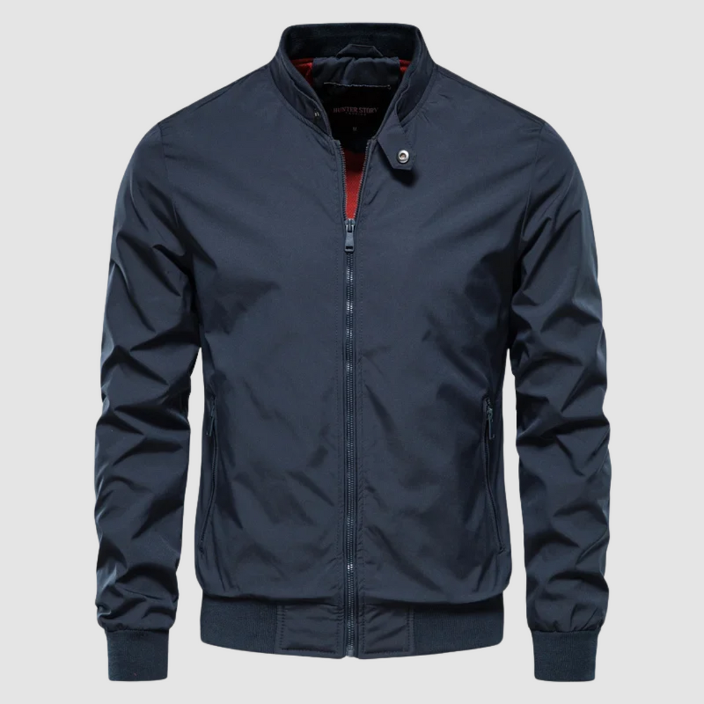 Front view of a dark blue lightweight bomber jacket with a simple design on a grey background.