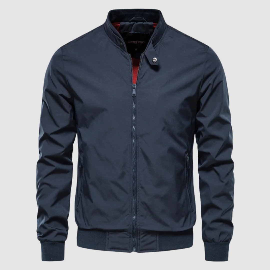 Front view of a dark blue lightweight bomber jacket with a simple design on a grey background.