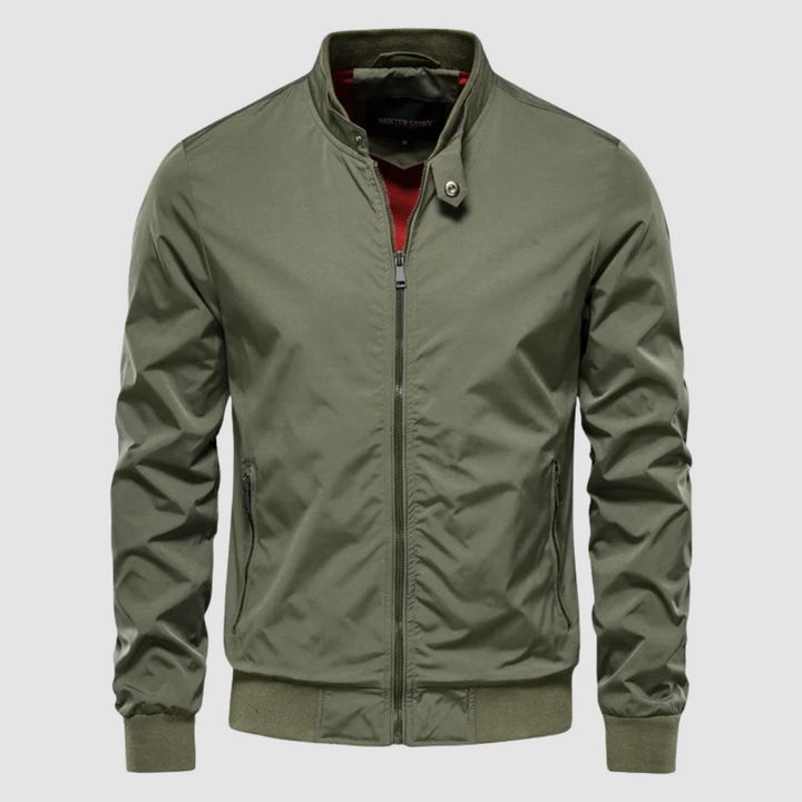 Front view of a green lightweight bomber jacket with a minimalist design on a grey background.