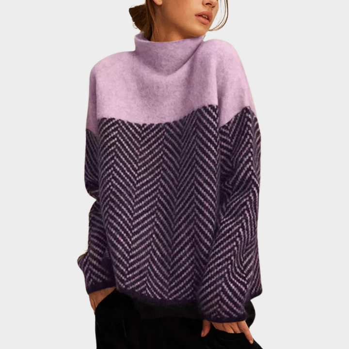 Two-tone, herringbone pattern sweater in lavender and dark purple, worn by woman, set against a plain background.