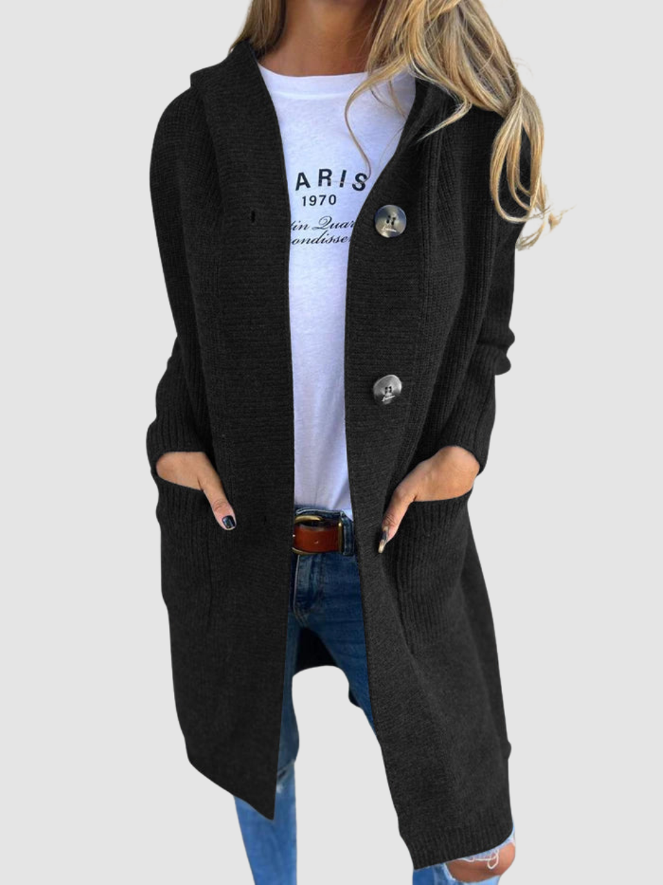 Black knitted cardigan with large buttons and pockets, worn over a white graphic tee and jeans in studio setting.