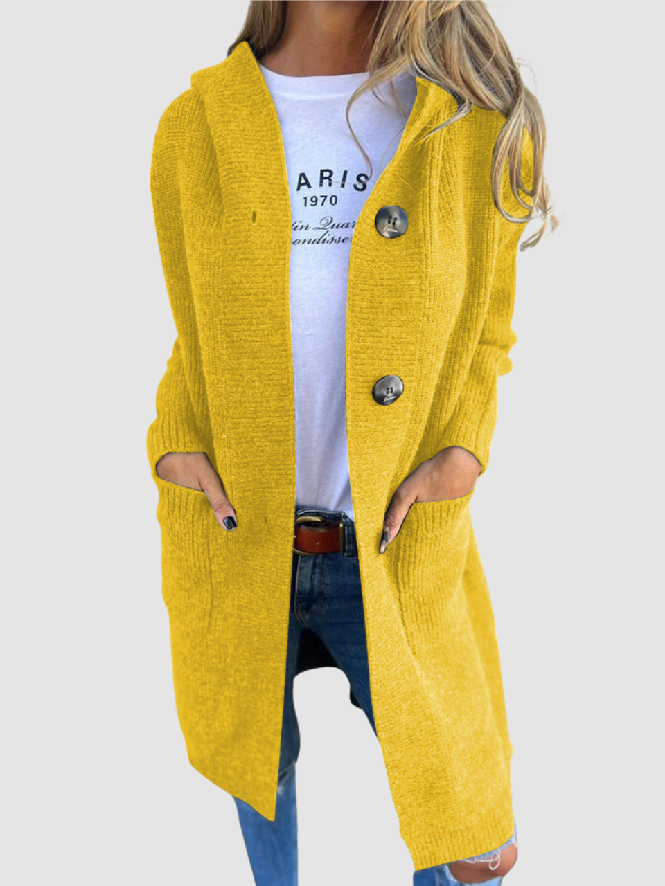 Yellow knitted cardigan with large buttons and pockets, worn over a white graphic tee and jeans in studio setting.
