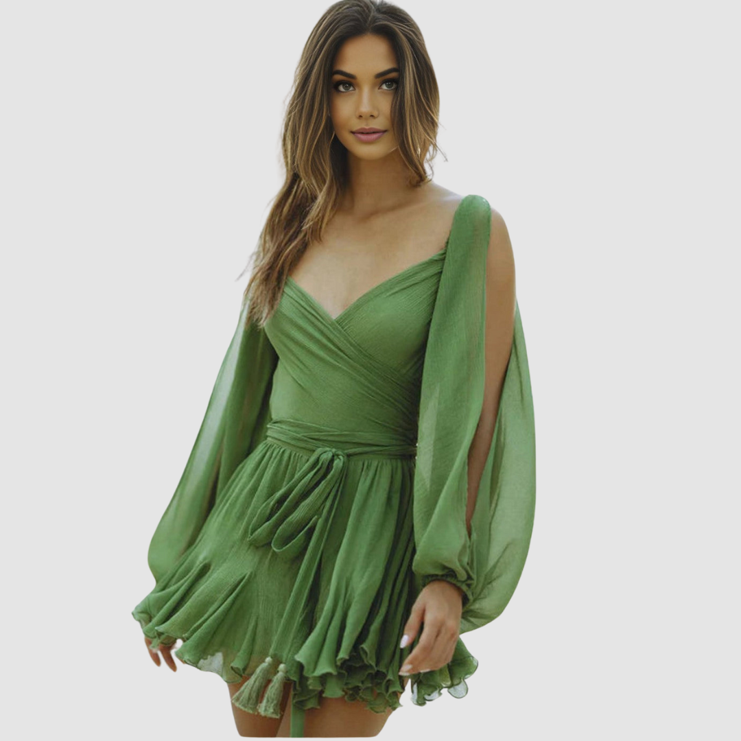 Woman in a green mini dress with flowing sleeves and wrap style, studio setting.