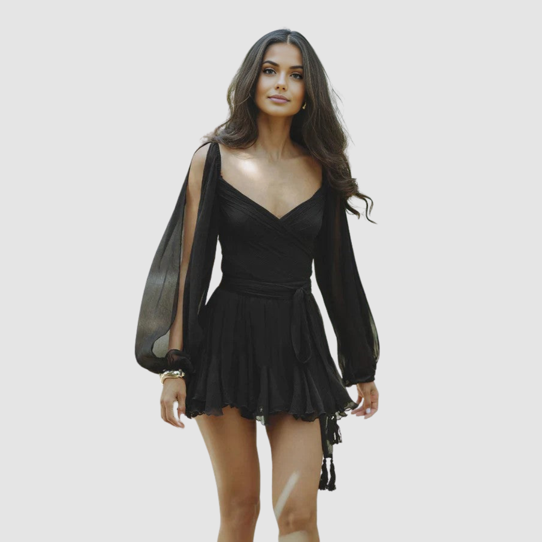 Woman in a black mini dress with flowing sleeves and wrap detail, studio setting.